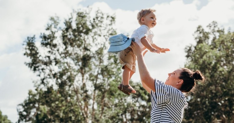 子どもを高く抱き上げる親
